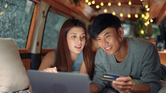 快乐的年轻亚洲夫妇在网上购物在汽车露营