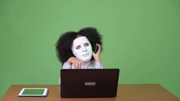 年轻可爱的非洲女孩与非洲发型作为黑客使用笔记本电脑