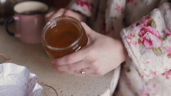 女性双手打开蜂蜜罐