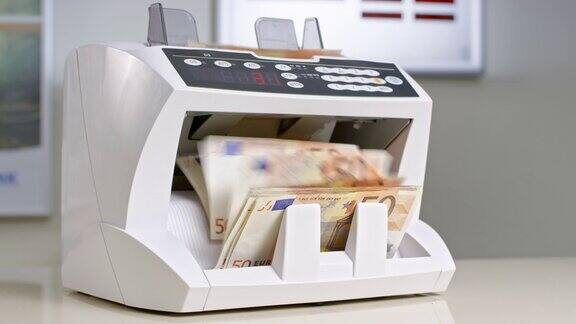 女银行职员将50张欧元钞票放入自动货币柜台