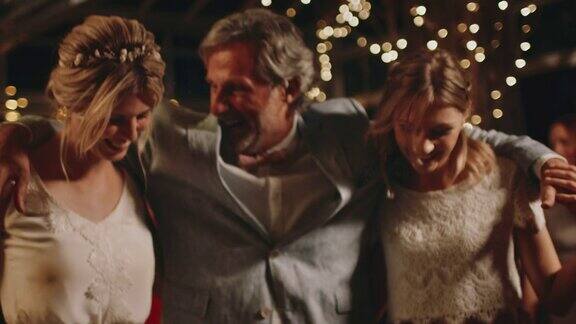 父亲在派对上与新娘和伴娘跳舞