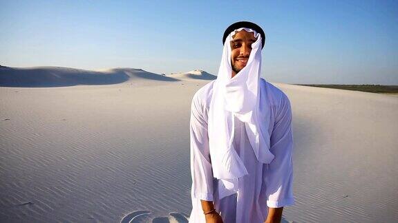 在晴朗的一天在白色的沙漠中慢动作自信的阿拉伯阿拉伯酋长酋长在坎杜拉