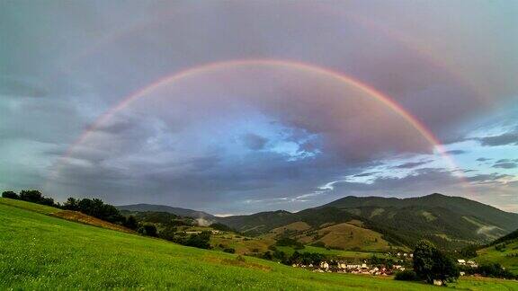 双彩虹在绿色草地和乡村景观与多云的天空时间流逝
