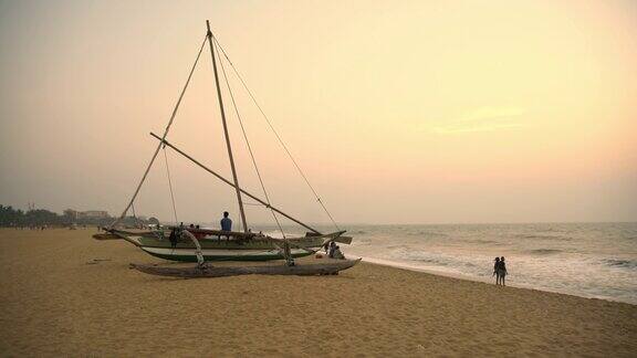 日落时分斯里兰卡渔船附近的海滩上
