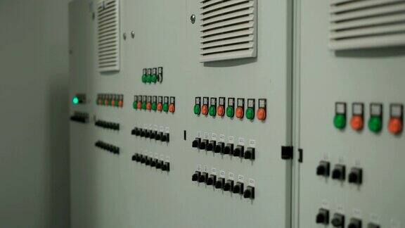 带有许多按钮和开关的大型灰色控制面板摄像机顺利移动沿墙与电子设备的工厂