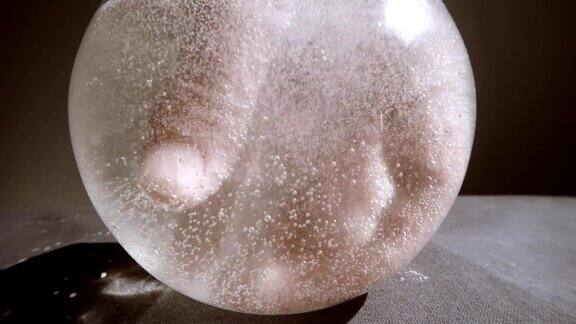 手出现在搅动水的白气泡在玻璃容器