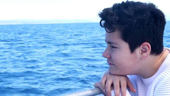 英俊的年轻男孩在海上坐船旅行