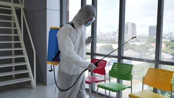清洁人员正在办公室喷洒冠状病毒以预防COVID-19