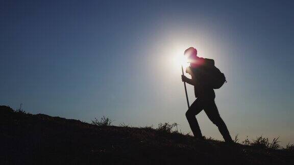 活跃的人在日落时用登山杆爬山