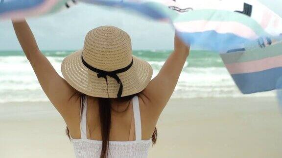 在沙滩上打着围巾的女人望着别处