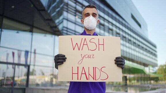 医生站在医院门前举着洗手的牌子