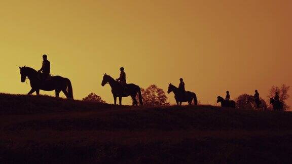 黄昏时分一群人骑马的剪影