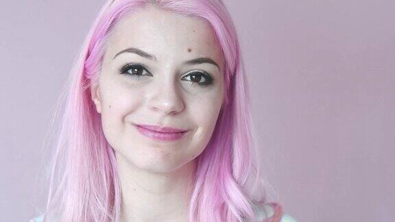 染成粉红色头发的年轻女子微笑着看着镜头