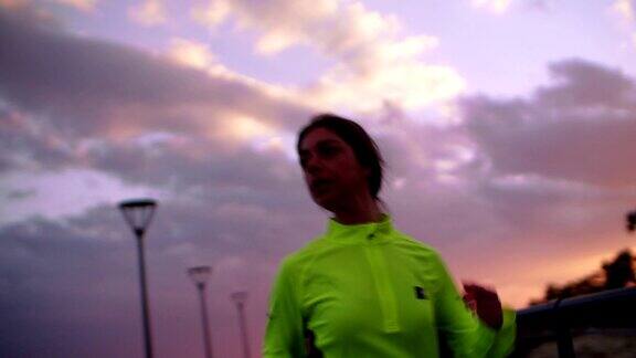 年轻健康的女人在日落时穿着运动服慢跑