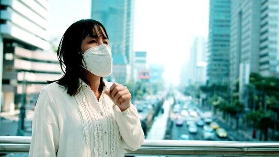 带防护口罩的女病人站在户外咳嗽
