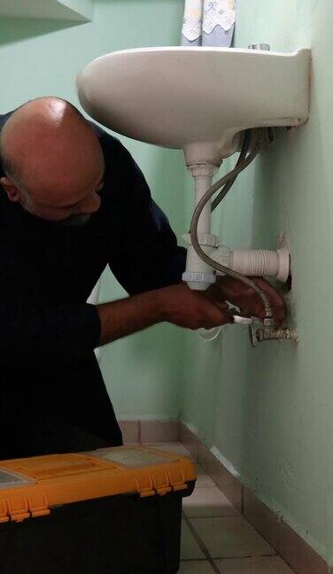 水管工人正在修理浴室的水槽软管