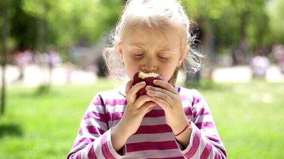 小女孩在操场上吃苹果