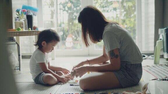 年轻的亚洲母亲和儿子用纸工艺品制作玩具