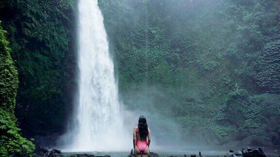 印度尼西亚巴厘岛的瀑布和女旅行者热带森林和瀑布