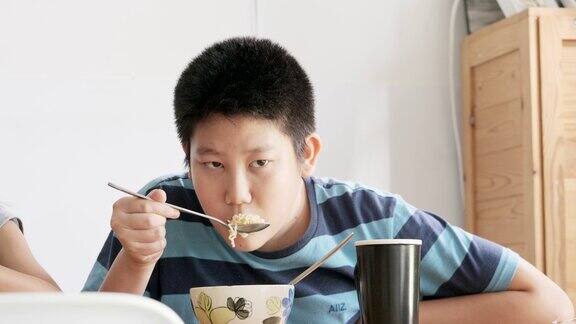 快乐的亚洲孩子在家里一起吃速食面汤生活理念