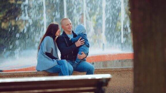 幸福的一家人坐在喷泉边