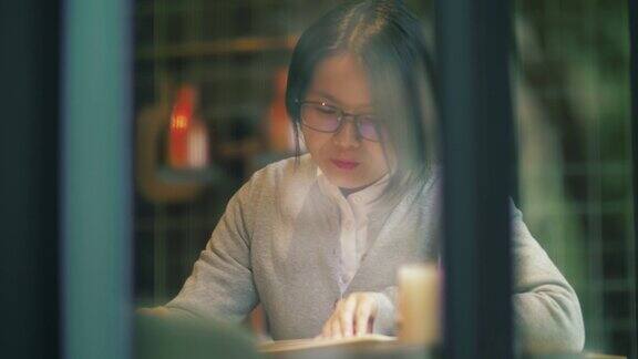 一个亚洲女人在咖啡厅看书