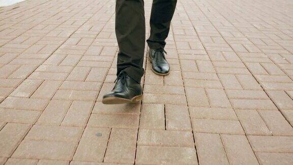 斯坦尼康镜头的特写镜头商人在鞋子走在街道的人行道上