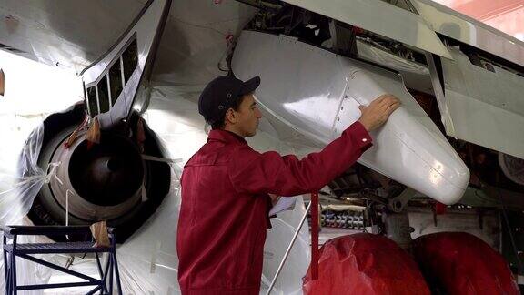 正在工厂修理飞机的工程师修理飞机机翼