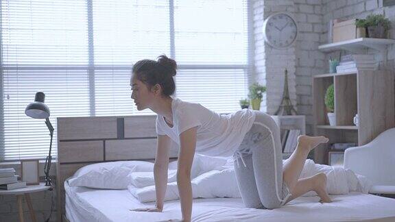 亚洲女性早上在床上锻炼她觉得精神焕发