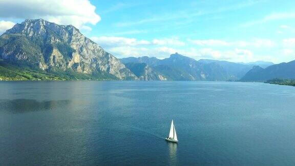 在奥地利阿尔卑斯山的风景中在清澈的山上和沃尔夫冈湖上拍摄游艇的电影