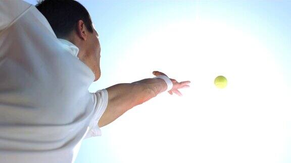 一个网球运动员向上扔网球