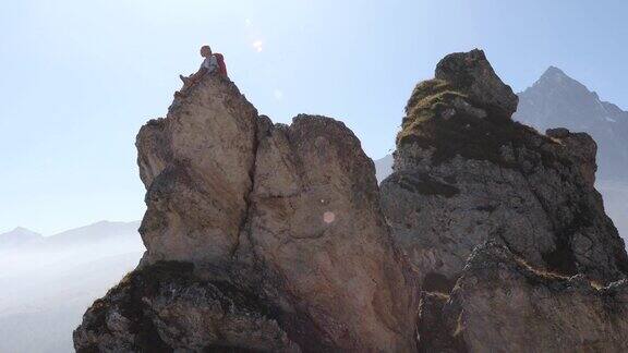 女登山运动员在峰顶或岩石顶峰休息