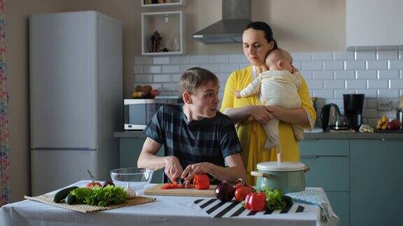 男人做饭妻子抱着孩子在厨房