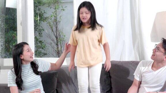 女儿跳到沙发上给父母看亚洲家庭花时间在一起