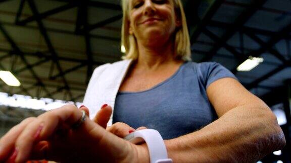 资深女性在健身工作室使用智能手表4k