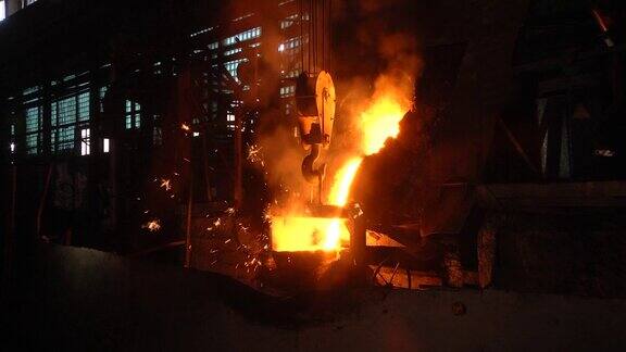 生产部门铸造在烧瓶中通过铸造制造金属产品的空间气化模型铸造车间熔化的金属从感应炉倒入钢包热金属的火花飞溅开来