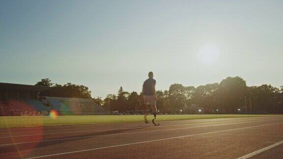 运动残疾人健美儿戴着义肢跑步刀片在阳光明媚的下午在户外体育场训练截肢跑步者在体育场跑道上慢跑激励运动镜头从后面拍摄