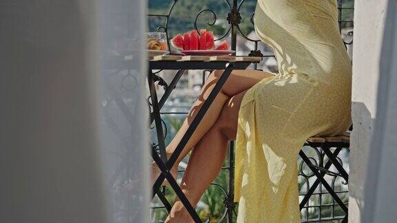 SLOMO女人在阳台上吃早餐可以看到海景