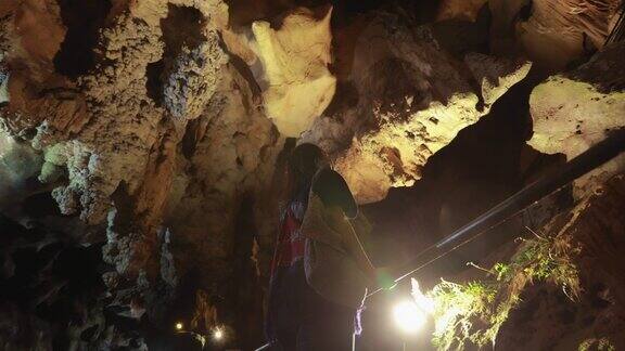 女游客走在洞穴探索和环顾四周