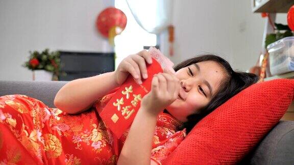 慢镜头快乐的亚洲女孩拿着春节庆祝活动的红包