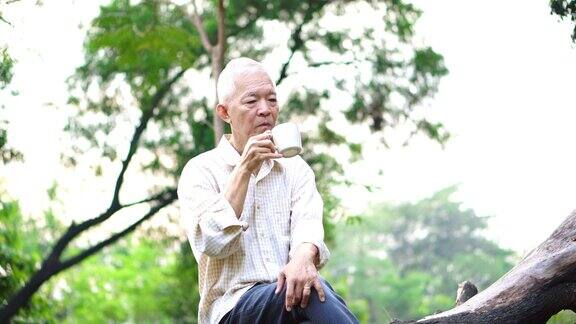 孤独的亚洲老人坐在公园里独自喝着咖啡思考着人生