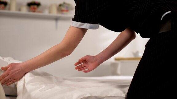 女佣在制服铺床整理床单高质量的清洁服务