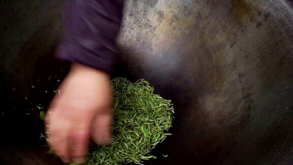 农民用传统的方法在铁锅里翻炒茶