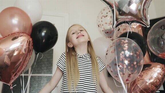 一个可爱的女孩微笑着手里拿着气球在她的生日