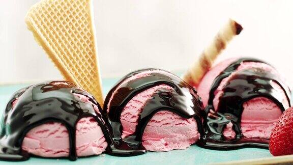 将巧克力酱浇在草莓冰淇淋上