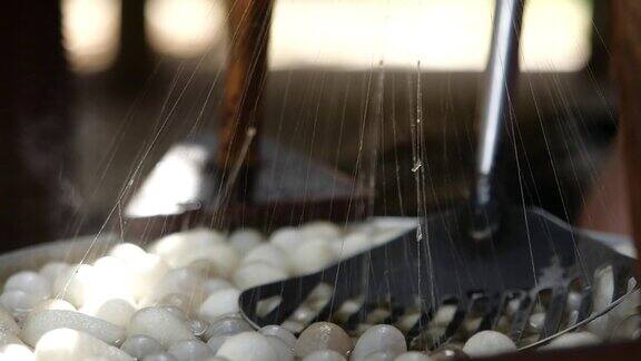 蚕茧在丝绸生产工匠特写蚕茧与蒸汽在慢动作