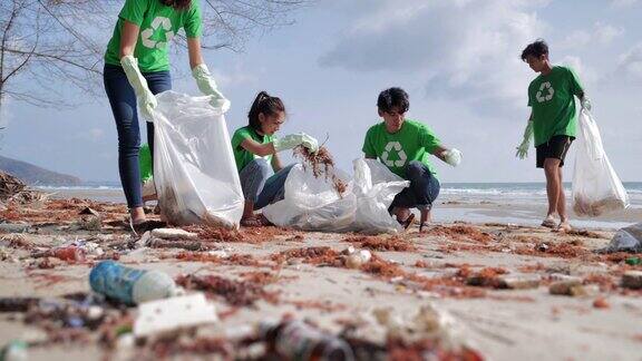 一群快乐的志愿者用垃圾袋清理海滩上的区域志愿、慈善、清洁、人与生态的观念志愿服务