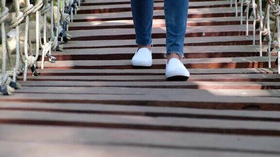 一个女人与白鞋走过木桥的特写