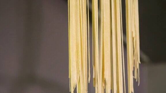 用黄绳子吊着新鲜的意大利面家里做的意大利面