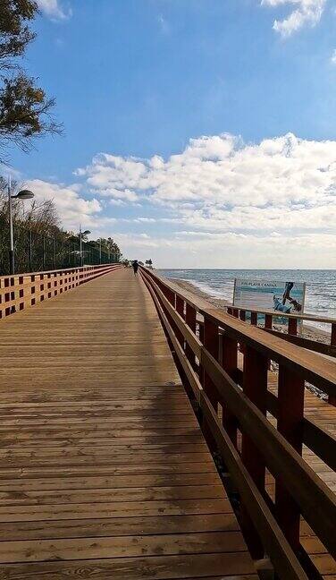 拍摄西班牙玛贝拉海滩上的一条空木栈道